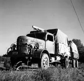 Flakbil, reg. nr. P3284, och släp transporterar material.