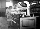 En kvinna arbetar vid ringspinningsmaskinen, Nääs fabrik.