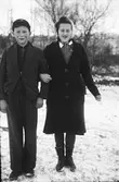 Ett syskonpar av de fem barnen Håkansson på Dämmarhult står arm i arm ute i snön. (Se även bilderna EA0201, EA0202)