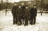 Hilma Håkansson i Dämmarhult tillsammans med sina fem barn framför Eriks kamera utomhus. Marken är snötäckt och en av pojkarna har lite snö på kläderna. (Se även bilderna EA0201, EA1211)
