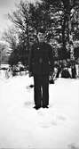 Yngligen Evert Klasson i Albäck poserar i uniform med skinnhandskar i snön. På rocken sitter ett märke som ser ut att ha med skytte att göra.
