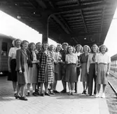 En grupp kvinnor står på perrongen, Alingsås järnvägsstation.