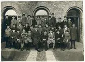 Västerås, Kyrkbacken, kv. Domkyrkan.
Rudbeckianska skolan - Högre Allmänna Läroverket. Gruppbild med lektor Erik Wahlberg och skolklass.