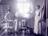 Läkare och sjuksystrar i operationssal runt en flickpatient på brits. (Se även bild MR2_1004)