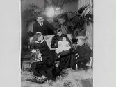 Familjefoto i heminteriör med fyra barn och föräldrarna.