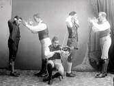 Folkdansare på ateljéfoto. Fyra män dansar 