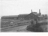 Varbergs snickerifabrik i kv Späckhuggaren. Fabriken har många olika tillbyggnader. I bakgrunden syns ett par cisterner.