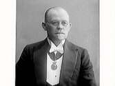 Porträtt av herre i glasögon med medalj om halsen. Se även MR2_2031, MR_2049)