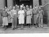 En grupp kvinnor och män fotograferade på en trappa utomhus vid Rosenfredsskolan. Möjligen personal.