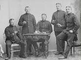 Ateljéfoto med fem militärer som skålar i punsch.