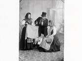 Tablå som föreställer en knalle som försöker sälja tyg till två damer. Han bär hög hatt käpp/stav samt håller i en lång pipa. Mannen är Elof Ernwald, damen till höger är Hulda Lindh (f Ranch). (Jämför foto MR2_984 o 985)