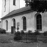 Alingsås stadskyrka med Alströmers grav framför ingången till kyrkan.