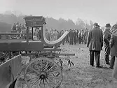 Vagnsauktion på Tjolöholm. Båda bilderna visar vagnar i förgrunden och auktionsbesökare i bakgrunden. Möjligen var detta 1964 i samband med att Göteborgs stad köpte godset av släkten Bonde, vilka före köpet höll en auktion på lösöre under två dagar. (Se även bild H2059_17-18)