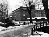 Bild på Kaboms fabriksbyggnad, tagen från Gasverksbron vintertid.