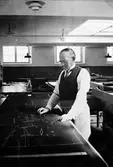 Skräddare och tillskärare August Wohlin i arbete på tillskärningsavdelningen på Kabom.