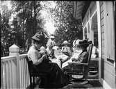Kvinnor sitter på verandan och handarbetar, Sätra brunn, Sala