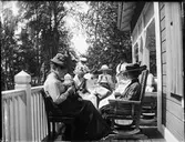 Kvinnor sitter på verandan och handarbetar, Sätra brunn, Sala