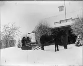 Två män sitter i släde bakom häst, Uppland