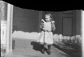 Flicka står på veranda, Uppland 1899