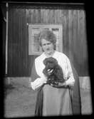 Kvinna med en hundvalp i famnen, Uppland