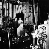 Tidsstudieman Ström i vit skjorta och slips i maskinverkstaden på AB Elektro-Apparat i kvarteret Yxan i Alingsås.