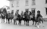 Barnens dag 1938. Sju män utklädda till cowboys sitter på var sin häst på gatan.
