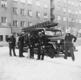 Brandmän framför brandbil, 1950-tal