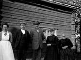 Grupp framför gammal stuga, september 1907
