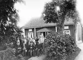 Grupp framför stuga, ca 1903