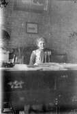 Ung kvinna vid skrivbord på Vasagatan 13, 1904