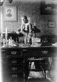 Ung kvinna i arbetsrum på Vasagatan 13, 1904
