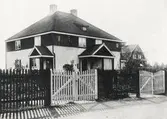 En villa på Söder (?) (Väster?), Växjö. Ca 1930. 
I bakgrunden syns ett nybyggt bostadshus med byggnadsställning.
