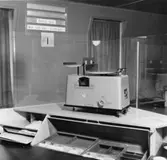 1955-års postkontor, rum 210 på 2 trappor. Kassaexpedition. Disk
med halvfrontal kassaplats.