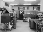 Till vänster står en IBM 1409 (?). Framför skåpen i fonden står en IBM
1403. Fönstren vetter mot öster.