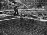 Byggarbetare bär på planka vid polishusbygget, 1956-06-19