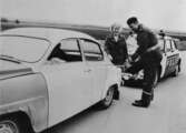 Polisman hjälper trafikant att tanka, 1960-tal