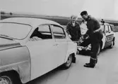 Polisman hjälper trafikant att tanka, 1960-tal