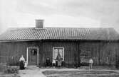 Familj framför hus i Rynninge, 1910-1920