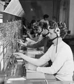 Centralposthusets telefonväxel, belägen i våningen 1 trappa, med entrén från Mäster Samuelsgatan 64. Växeln betjänas av ett stort antal damer som bl a kopplar samtal till postgirot.