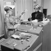 Clearingexpeditionen mottar på morgonen checkar, postväxlar och studiemedelsanvisningar som lösts in i postkassorna föregående dag. I clearingmaskinerna, som har 24 räkneverk, sorteras och summeras checkarna för varje bank. Leveransen går till Riksbanken, som sköter
avräkningen mellan bankinstituten.

IBM 802 Proof Machine.

IBM 802 Proof Machine.