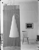 HÄNGANDE VIT PLASTSTRUT MED RANDIGT DRAPERI OCH PINNSTOL