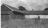 Övergiven gård mittemot Vrå i Onsala. Ekonomibyggnad i vinkel med boningshuset.