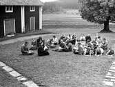 Flickor sitter ute och läser, 1930-tal