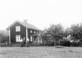 Familj framför hus, 1909