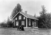 Familj framför sitt hus, 1917