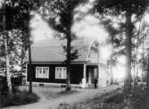 Familj framför hus, 1917