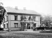 Familj framför hus i Löfsta, 1920