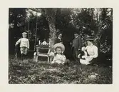 En familj poserar i en trädgård. Ca 1910.