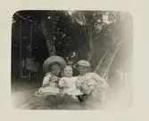 Några barn (syskon) poserar i en trädgård. Ca 1910.