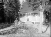 Kvinna framför hus, 1920-tal